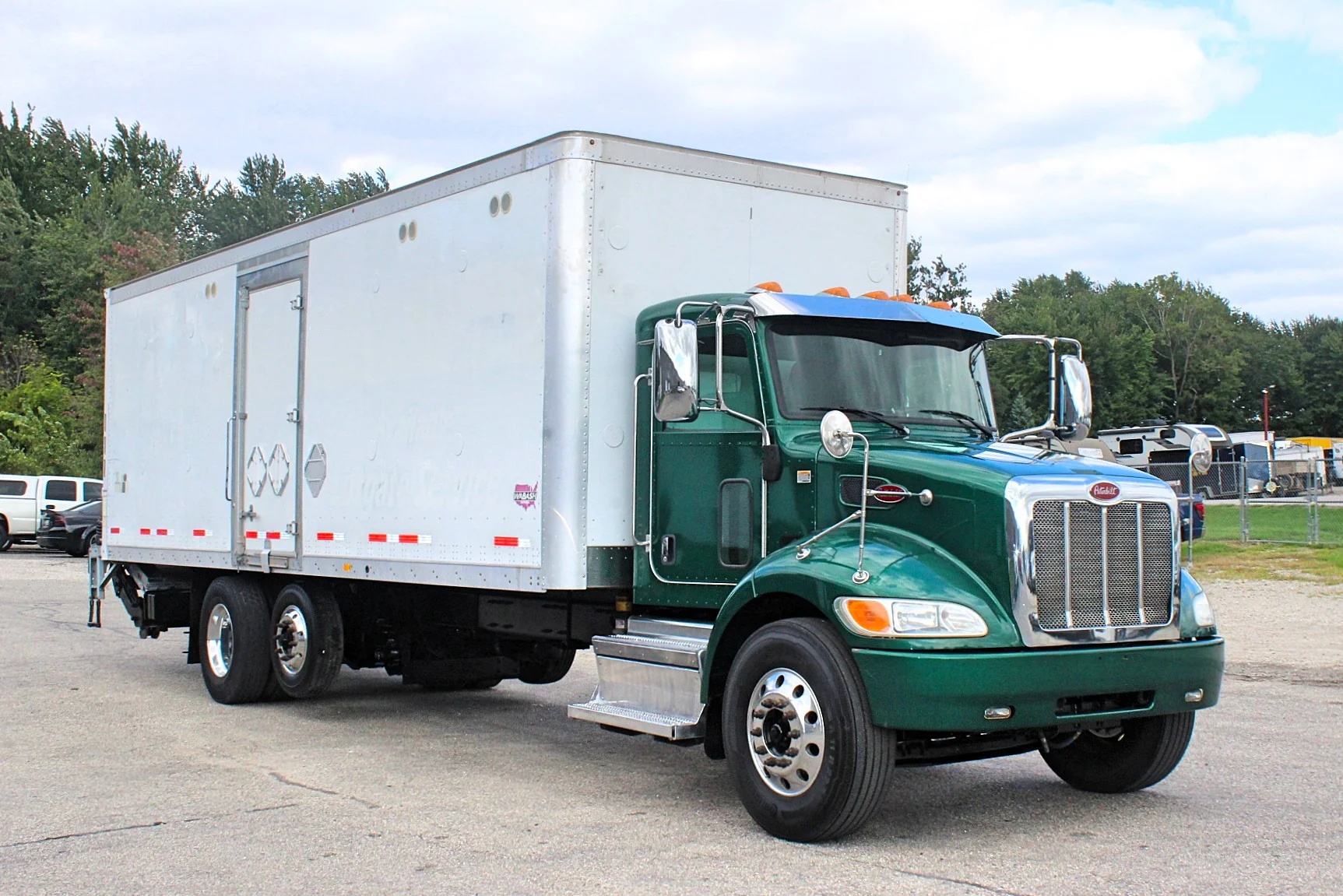 2018 Peterbilt 348 box truck – front three-quarter view with green cab and white cargo box