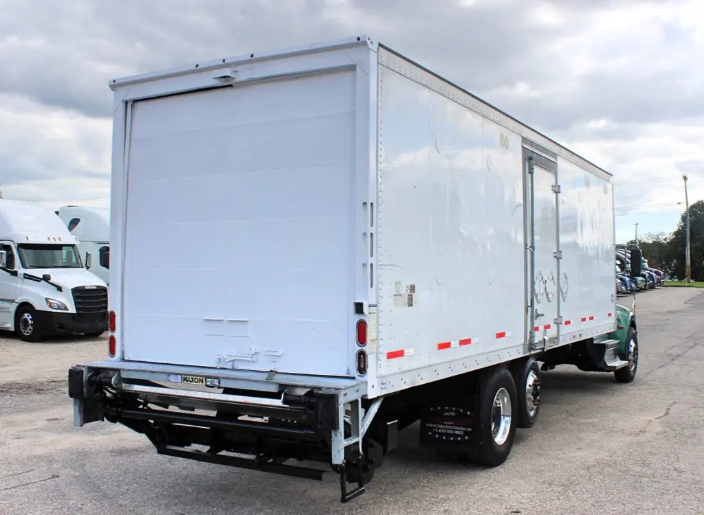 2018 Peterbilt 348 box truck – rear passenger-side view showing cargo box and Maxon liftgate