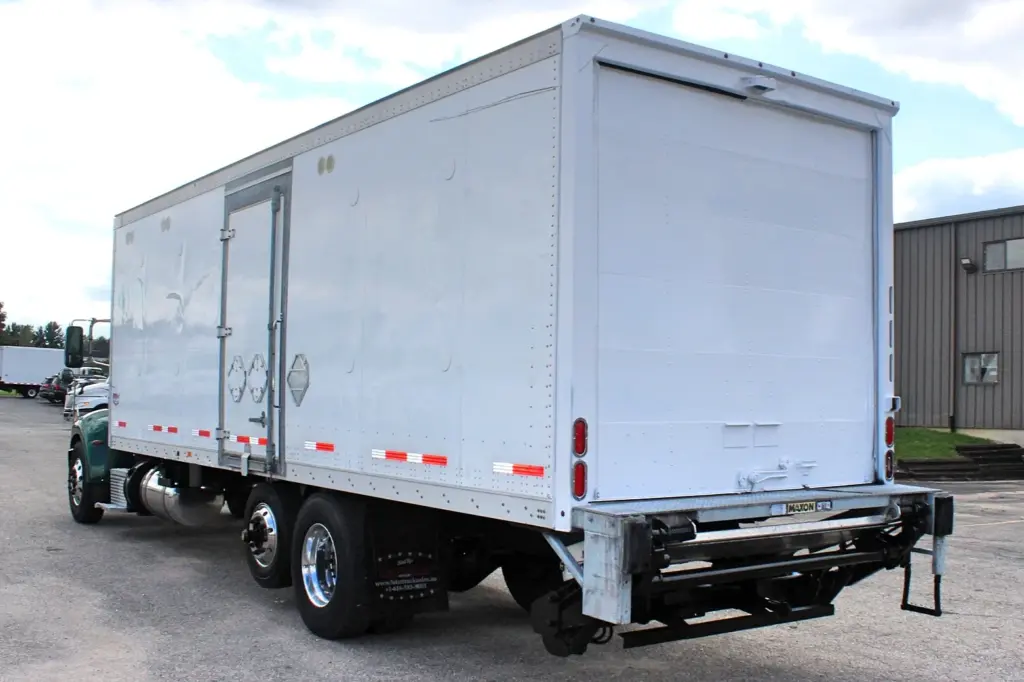 2018 Peterbilt 348 box truck – rear driver-side view showing white cargo box and Maxon liftgate