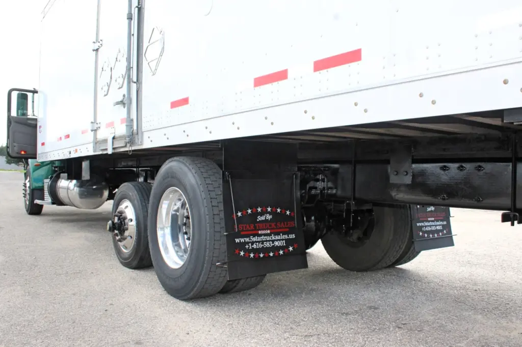 2018 Peterbilt 348 box truck – underside rear angle showing tandem wheels, mudflaps and frame