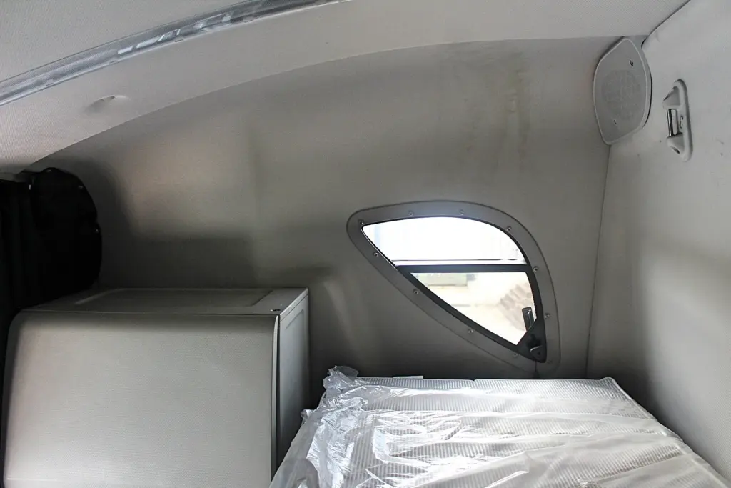 2019 Freightliner Cascadia 126 – upper sleeper area with side window, mattress and storage cabinet