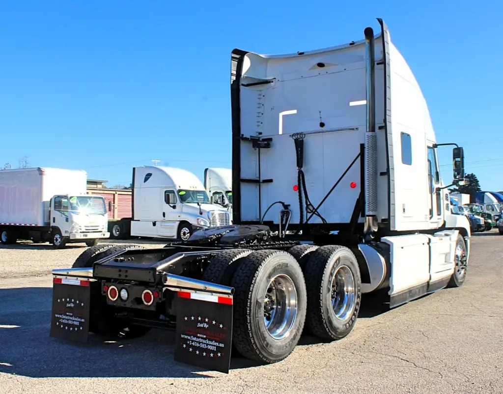 2023 Mack Anthem — rear three-quarter view of white sleeper tractor with tall cab fairing, dual stacks and mud flaps