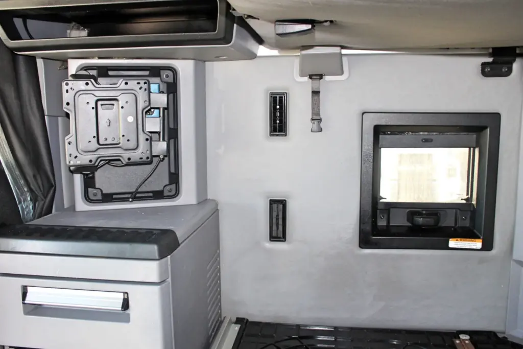 2023 Mack Anthem — sleeper rear wall with TV mounting bracket, gray fridge unit with drawer, air vents and small window