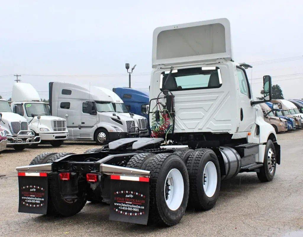 2019 International LT625 – rear three-quarter view of white day cab tractor and tandem axles.