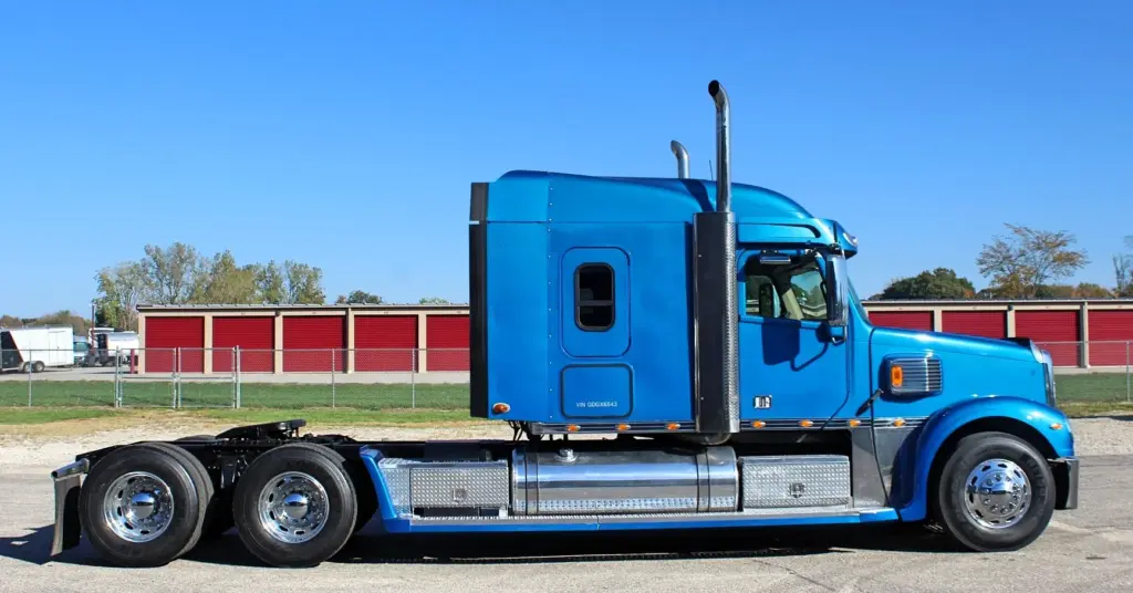 2016 Freightliner Coronado 132 — side profile of a blue sleeper with chrome tanks and aluminum wheels