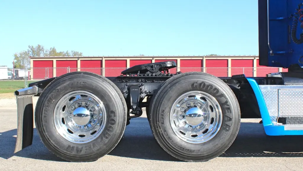 2016 Freightliner Coronado 132 — low side close-up of tandem drive axles, polished aluminum wheels and a black mud flap