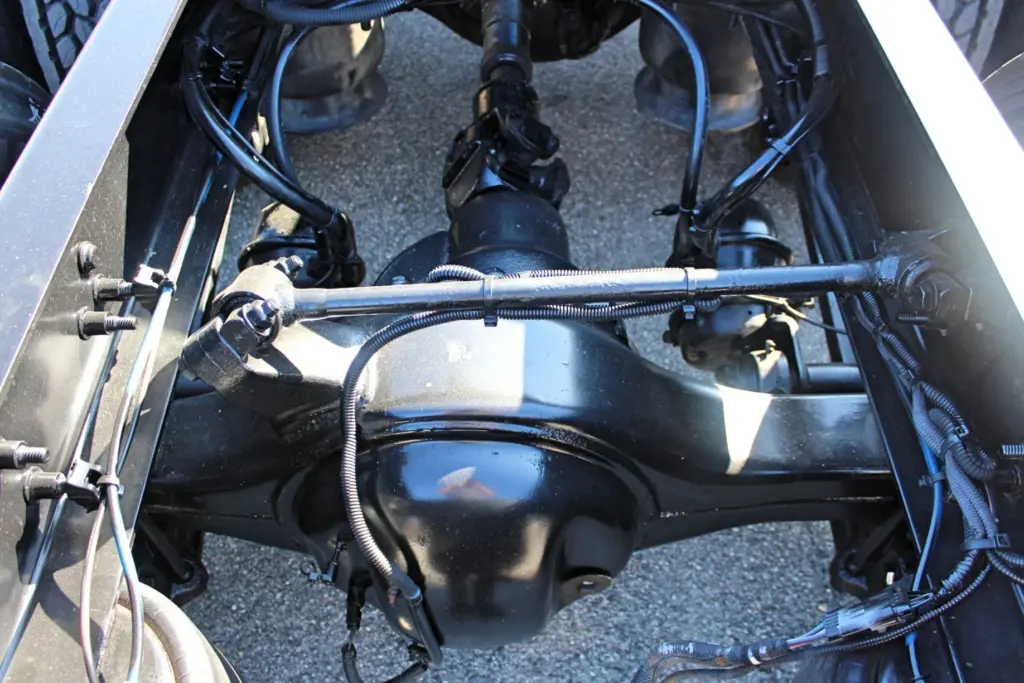 2016 Freightliner Coronado 132 — underside view of black drive axle housing, torque rod and wiring along the frame