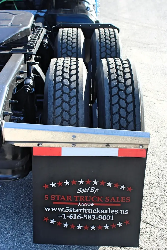 2016 Freightliner Coronado 132 — close rear view of four dual tires with deep tread and a black flap under an aluminum bar