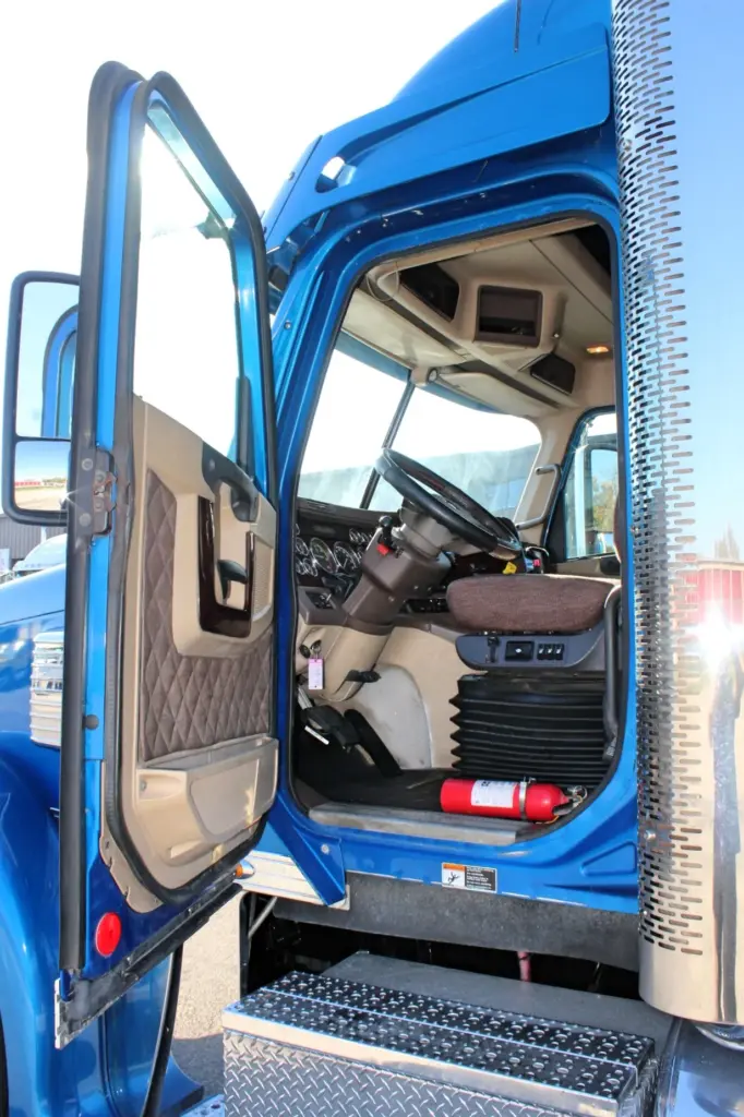 2016 Freightliner Coronado 132 — open driver door showing steering wheel, gauge cluster and brown quilted door panel