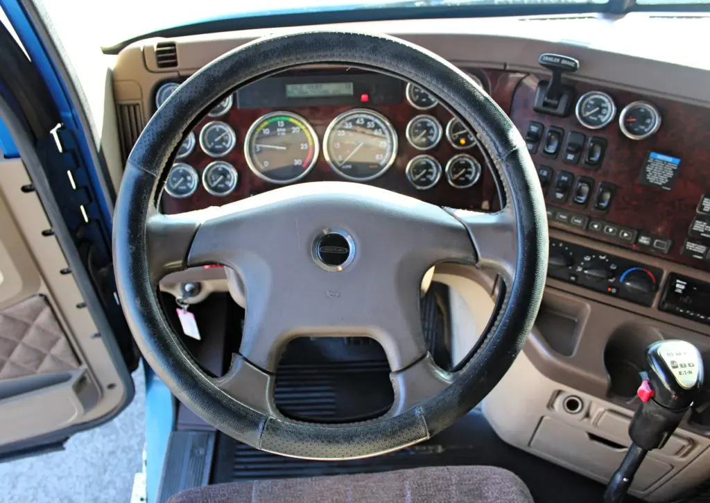 2016 Freightliner Coronado 132 — dash view through the wheel with round gauges, Eaton Fuller shift knob and climate dials