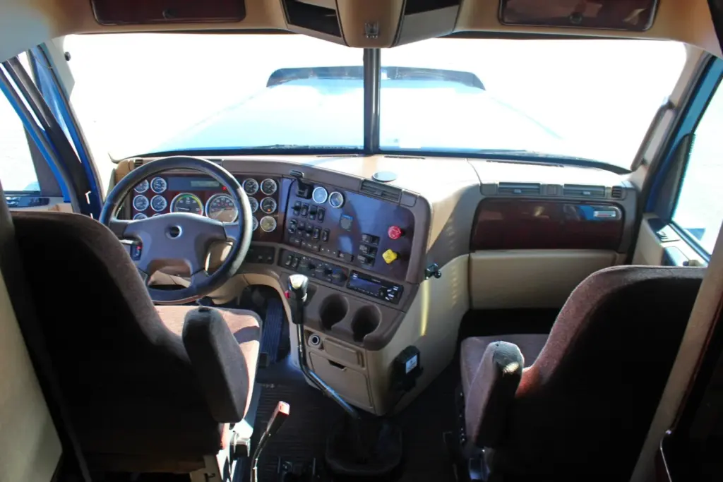 2016 Freightliner Coronado 132 — cab looking forward past the windshield at tan dash, gauges and two brown seats