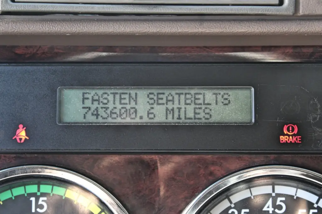 2016 Freightliner Coronado 132 — close-up of dash display reading fasten seatbelts beside brake warning lamp