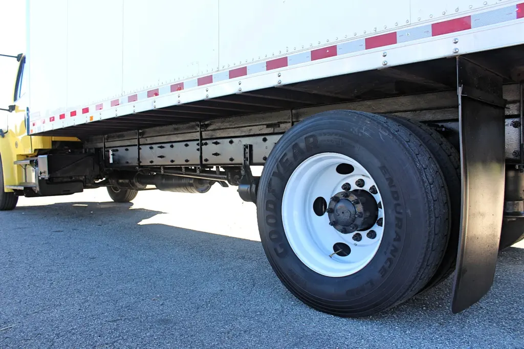 2016 Freightliner M2-106 Box Truck – close-up of rear axle, dual tires and commercial box truck chassis.