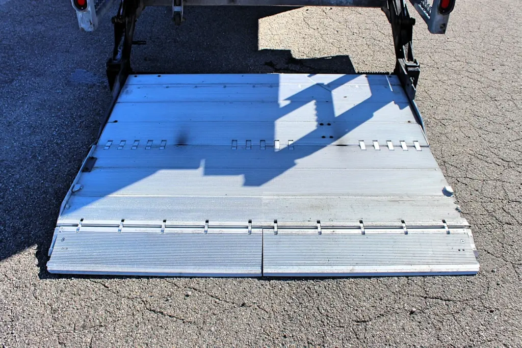 2016 Freightliner M2-106 Box Truck – close-up of the aluminum hydraulic liftgate platform fully lowered to the ground.