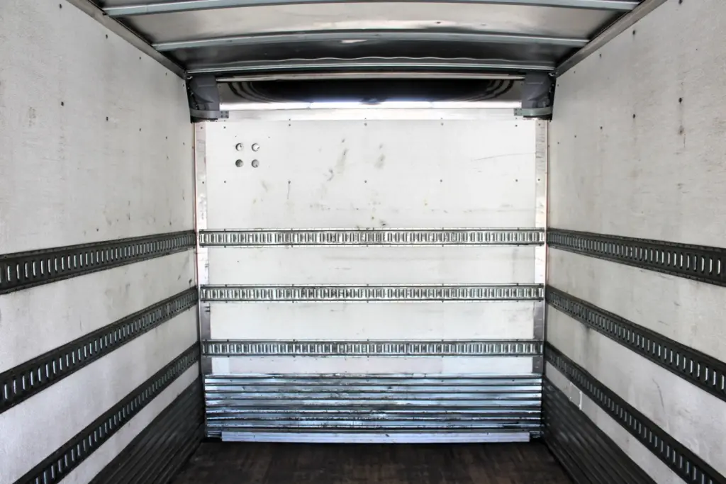 2016 Freightliner M2-106 Box Truck – centered interior view toward the front wall of the Morgan cargo box with E-track rails and scuff liner.