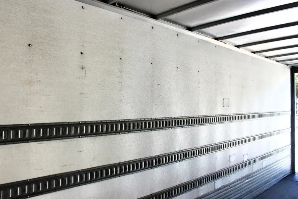 2016 Freightliner M2-106 Box Truck – opposite cargo box interior wall showing E-track freight securement rails and rear opening.