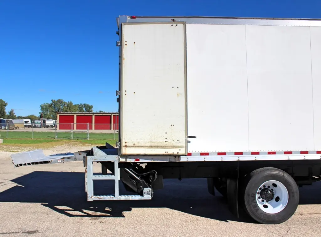 2016 Freightliner M2-106 Box Truck – exterior rear-side view with one swing cargo door open and hydraulic liftgate extended.
