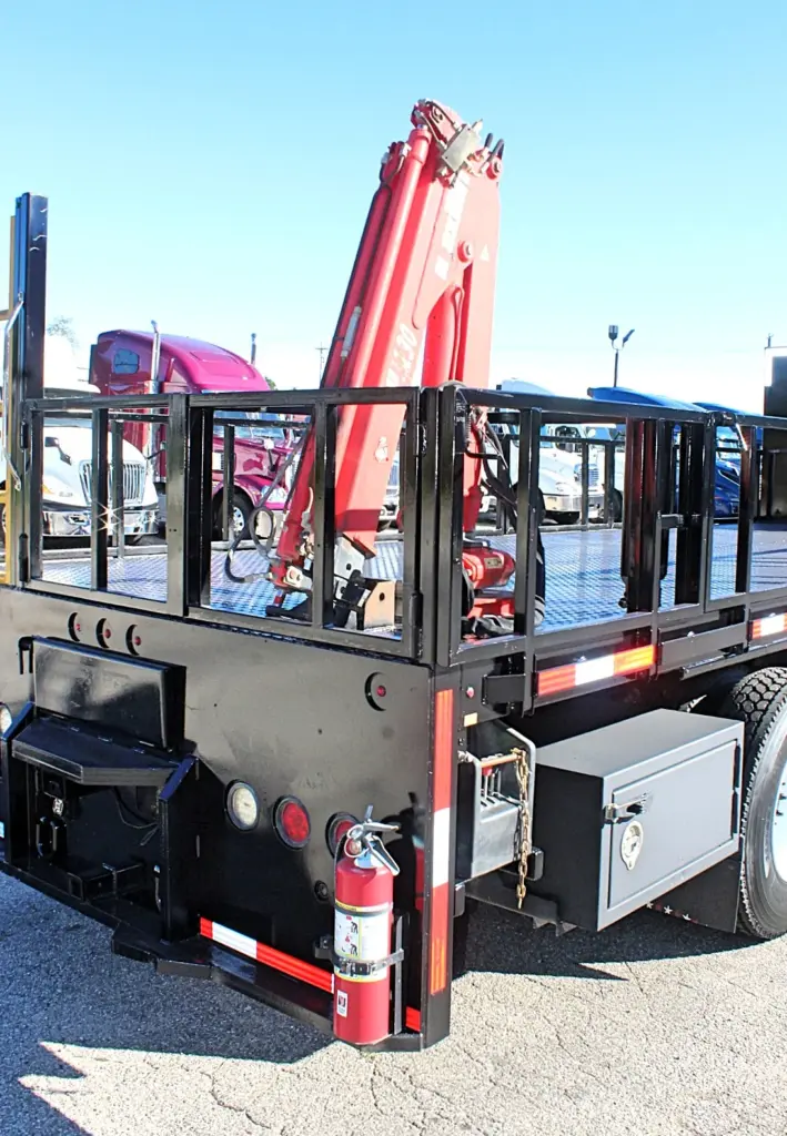 2018 Freightliner 114SD – rear corner view showing folded hydraulic crane, stake body, storage box and fire extinguisher.
