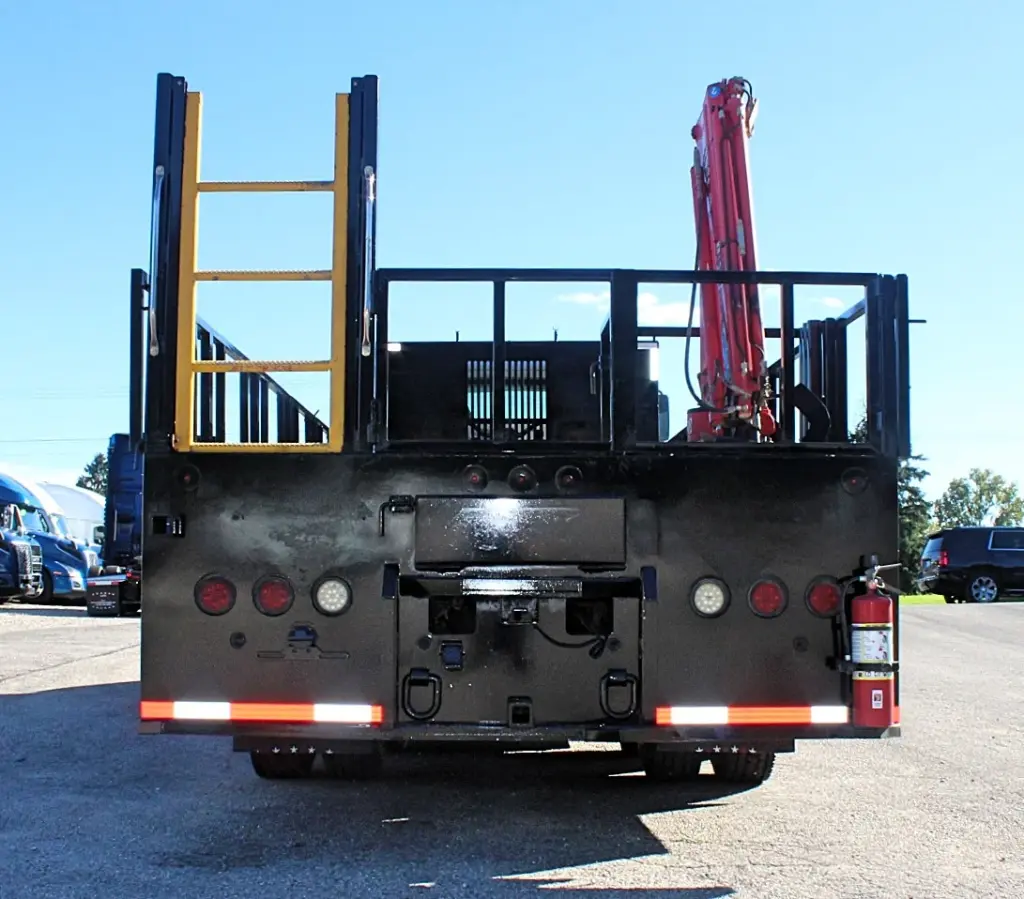 2018 Freightliner 114SD – straight rear view of stake bed crane truck with access ladder and equipment storage.