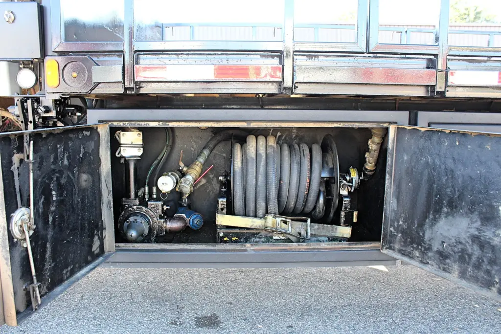 2018 Freightliner 114SD – side equipment compartment with hose reel, pump and fluid transfer connections.