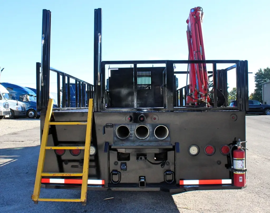 2018 Freightliner 114SD – rear view of crane truck with access ladder, pipe holders and flatbed stake body.