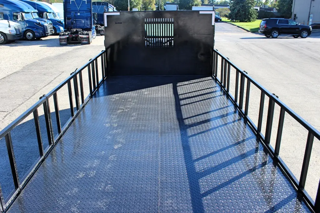 2018 Freightliner 114SD – diamond plate flatbed deck with stake sides and heavy-duty front bulkhead.