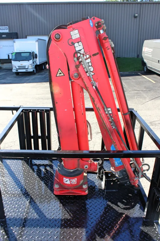 2018 Freightliner 114SD – close-up of folded red hydraulic knuckle boom crane mounted to flatbed.