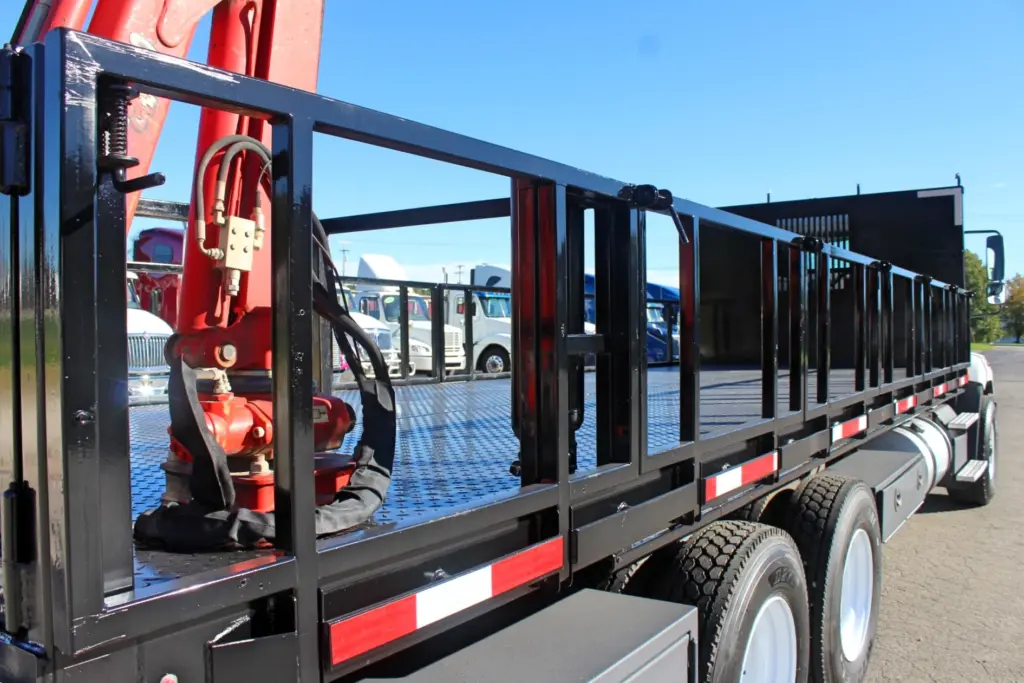 2018 Freightliner 114SD – stake body side rails, diamond plate deck and rear-mounted hydraulic crane.