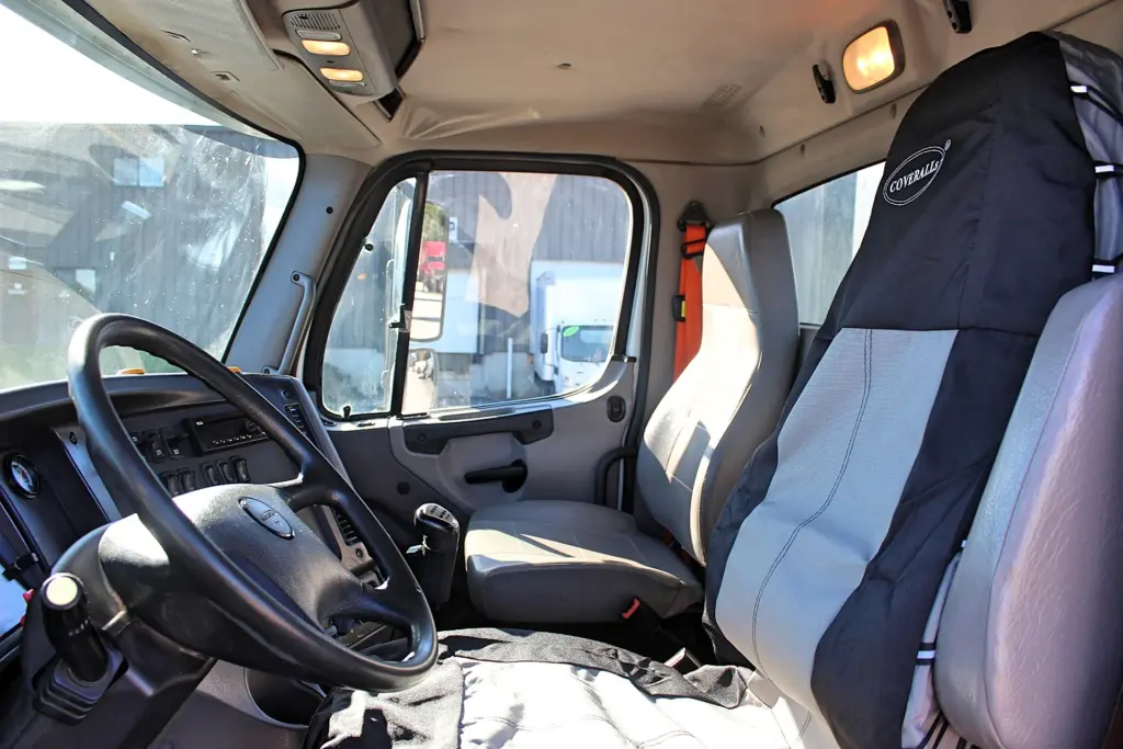 2018 Freightliner 114SD – clean vocational truck cab interior with driver and passenger seating.