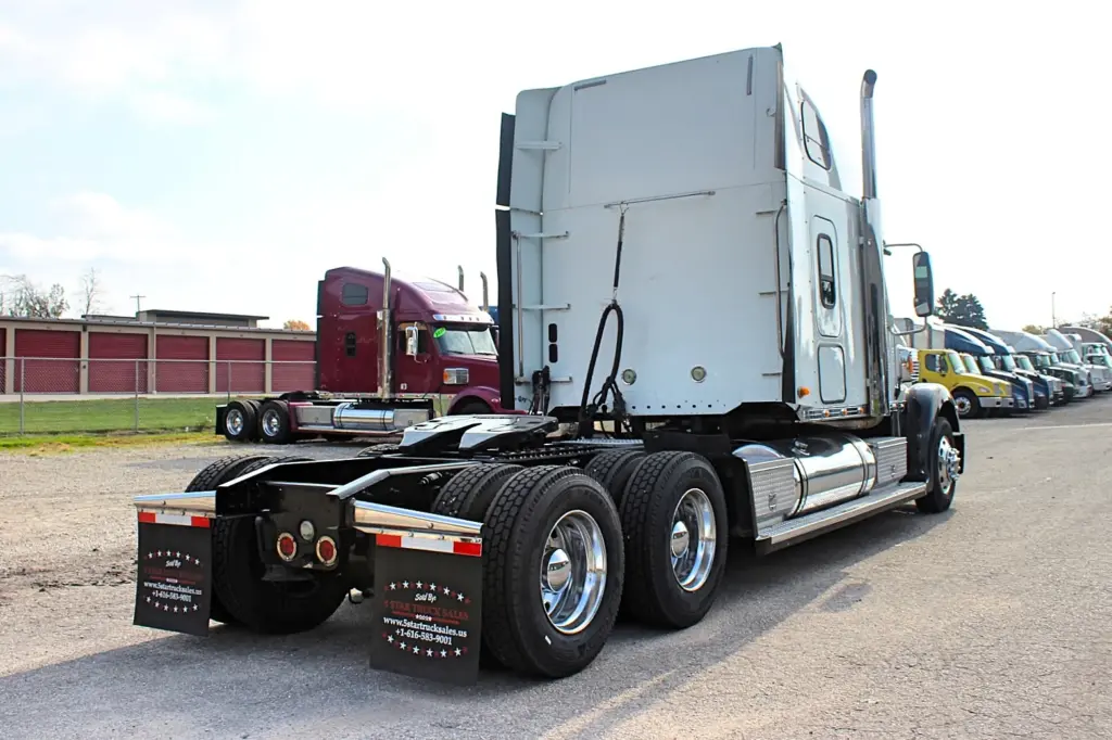 2018 Freightliner Coronado 132 — rear angle of white sleeper tractor showing chrome stack and polished aluminum wheels