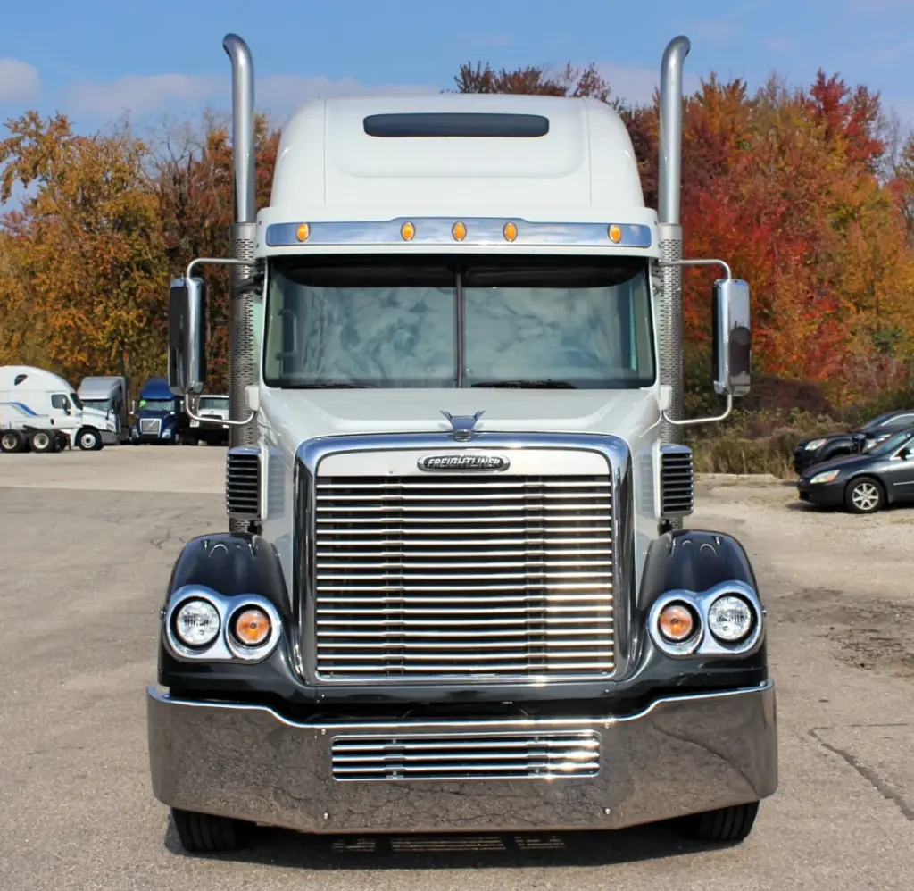 2018 Freightliner Coronado 132 — straight-on front view of white sleeper with polished bumper, twin stacks and headlamps