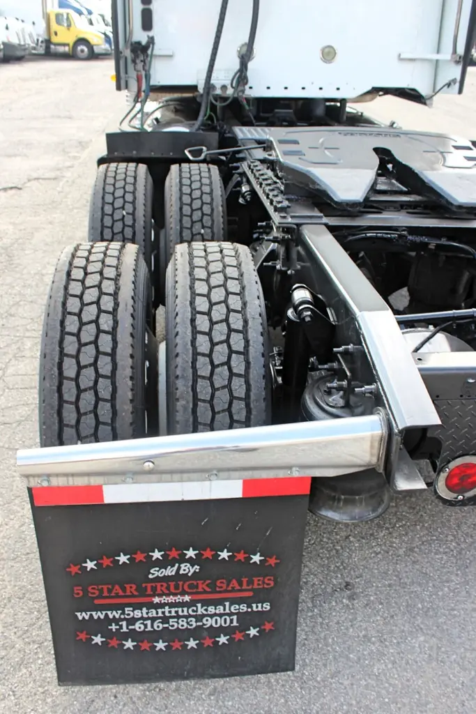 2018 Freightliner Coronado 132 — rear-facing close look at dual drive tires, chrome fender edge and hanging black mud flap