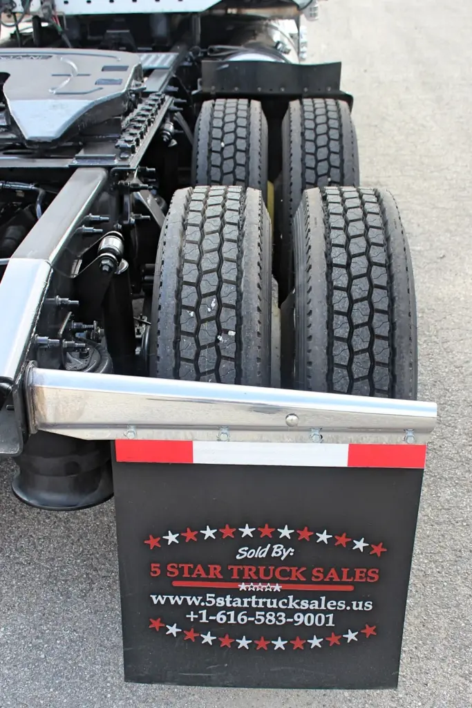 2018 Freightliner Coronado 132 — low angle on four rear drive tires, polished fender edge and black flap with red stripe