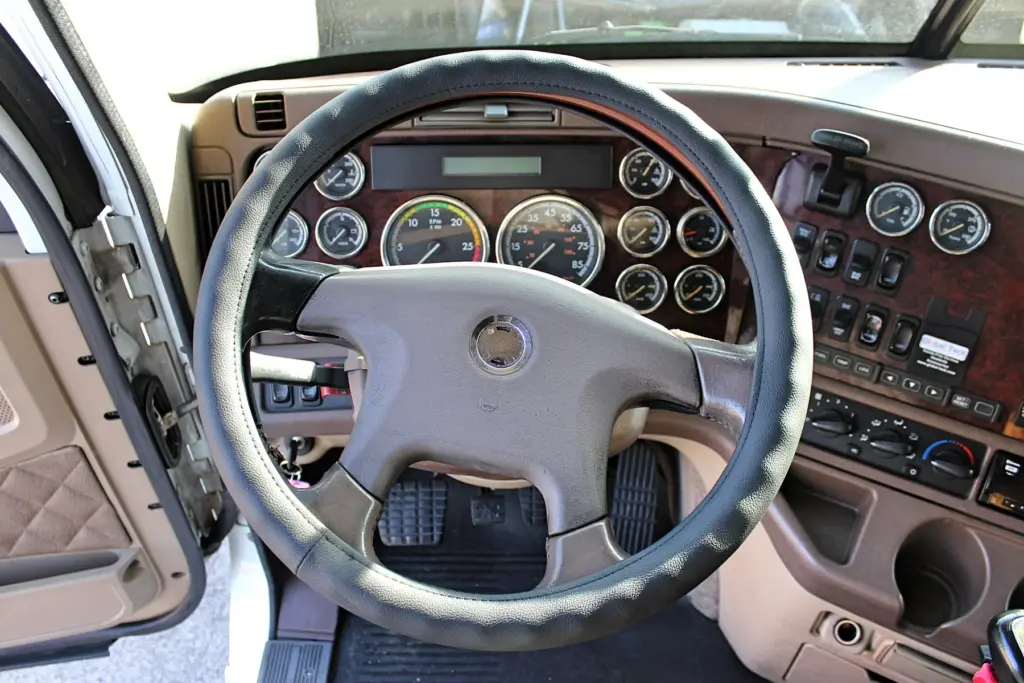 2018 Freightliner Coronado 132 — cockpit gauges and black leather-look wheel framed by wood-grain dash trim