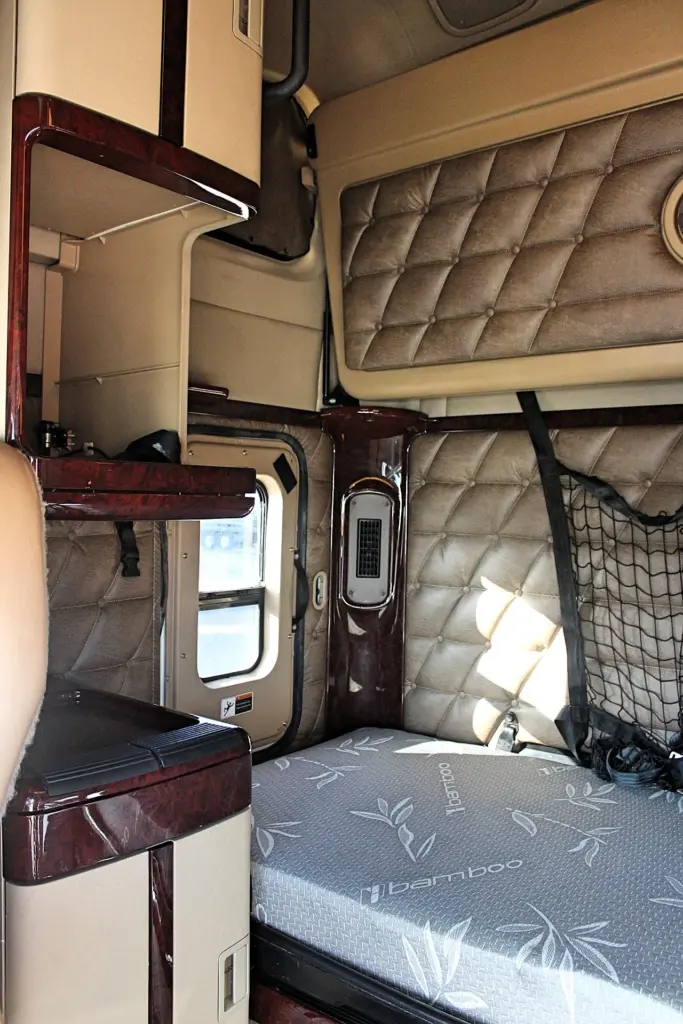 2018 Freightliner Coronado 132 — interior view of sleeper bunk with gray mattress and quilted brown wall panels