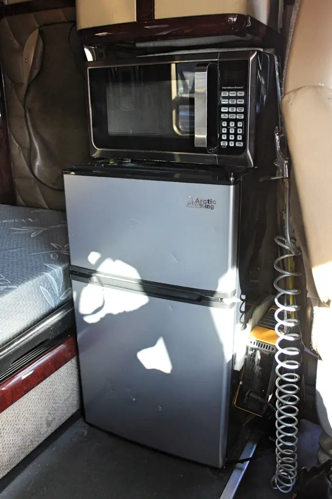 2018 Freightliner Coronado 132 — front view of silver mini fridge with microwave on top and coiled cord