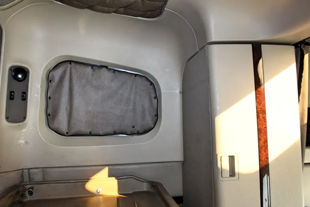 2018 Freightliner Coronado 132 — wide shot of sleeper wall with screwed gray panel, switch pod and wood-grain trim