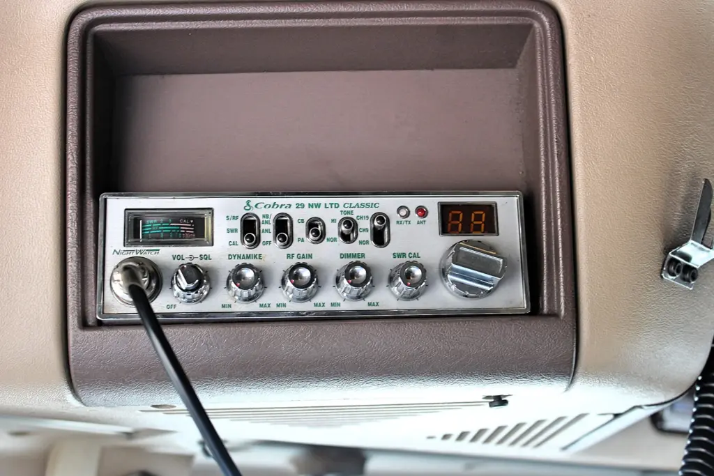 2018 Freightliner Coronado 132 — front view of dash-mounted CB radio with chrome knobs, green labels and black coiled cord