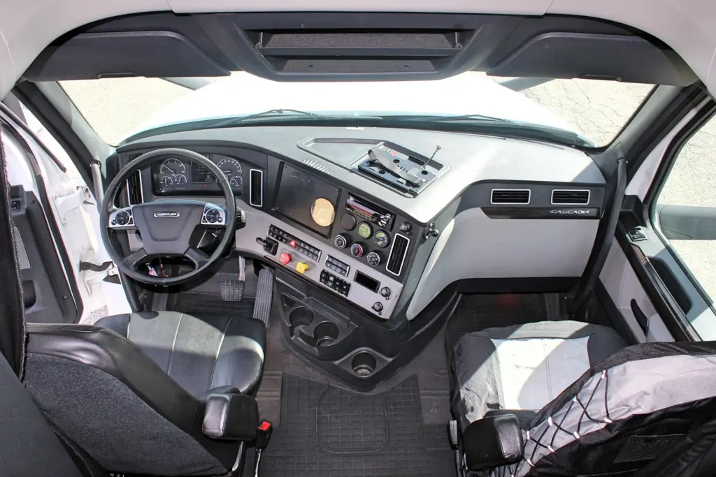 2019 Freightliner Cascadia 126 – wide interior view of dashboard, steering wheel and front seats.