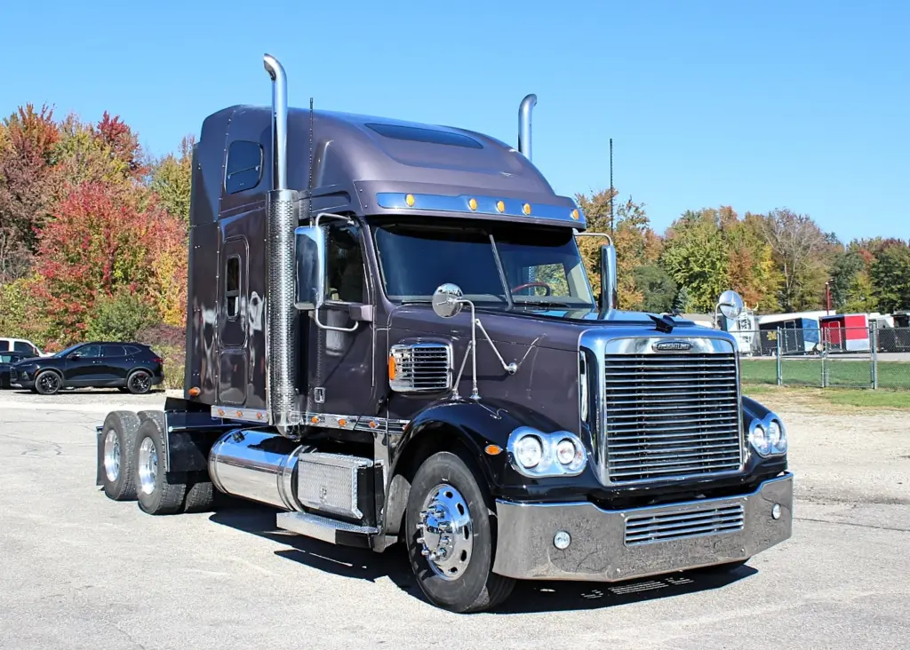 2020 Freightliner Coronado 132 — front three-quarter view of dark brown sleeper with chrome stacks and aluminum wheels