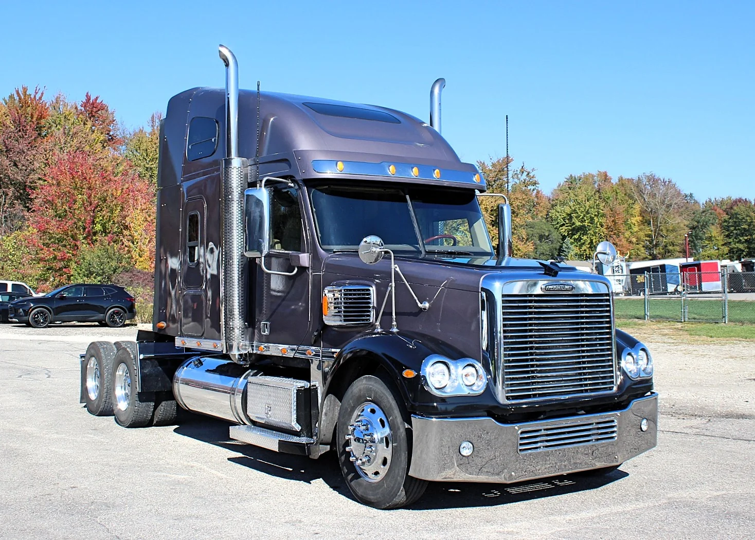 2020 Freightliner Coronado 132 — front three-quarter view of dark brown sleeper with chrome stacks and aluminum wheels