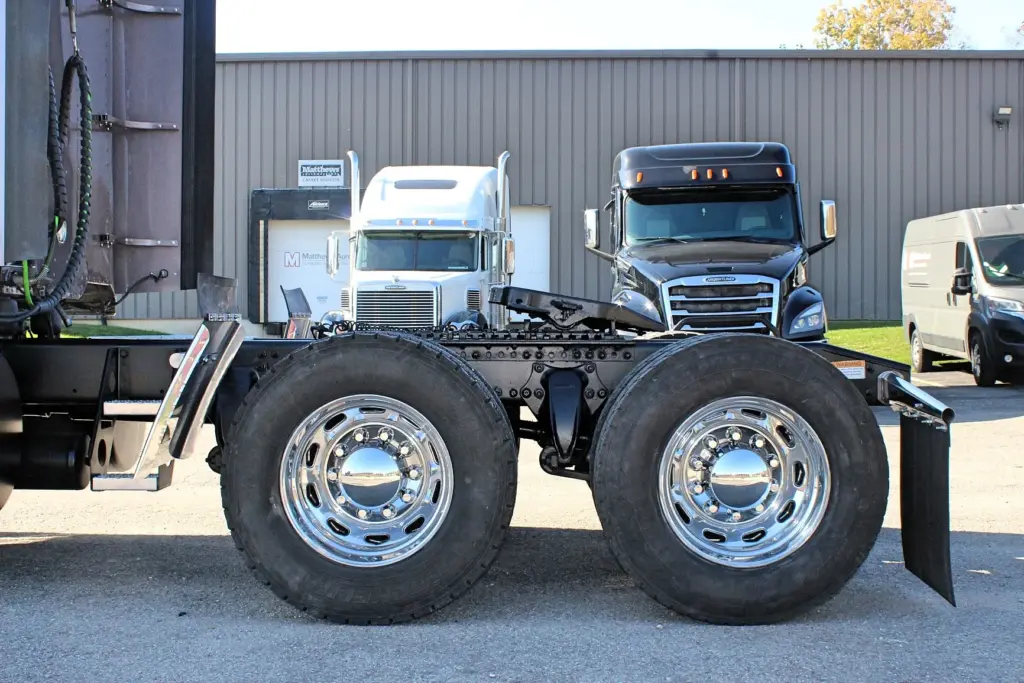 2020 Freightliner Coronado 132 — side view of bare frame with tandem axles and polished aluminum wheels