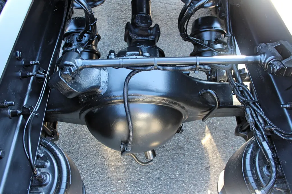 2020 Freightliner Coronado 132 — underside of black rear axle housing with driveshaft yoke and air springs