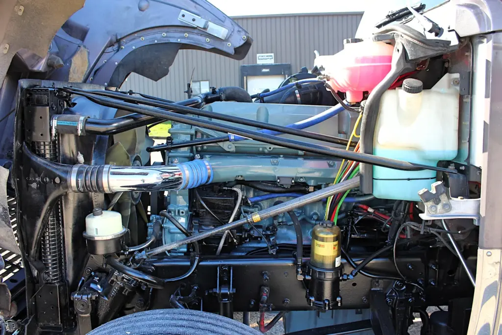 2020 Freightliner Coronado 132 — close view of blue Detroit 12.7L engine with chrome intake tube and yellow fuel filter