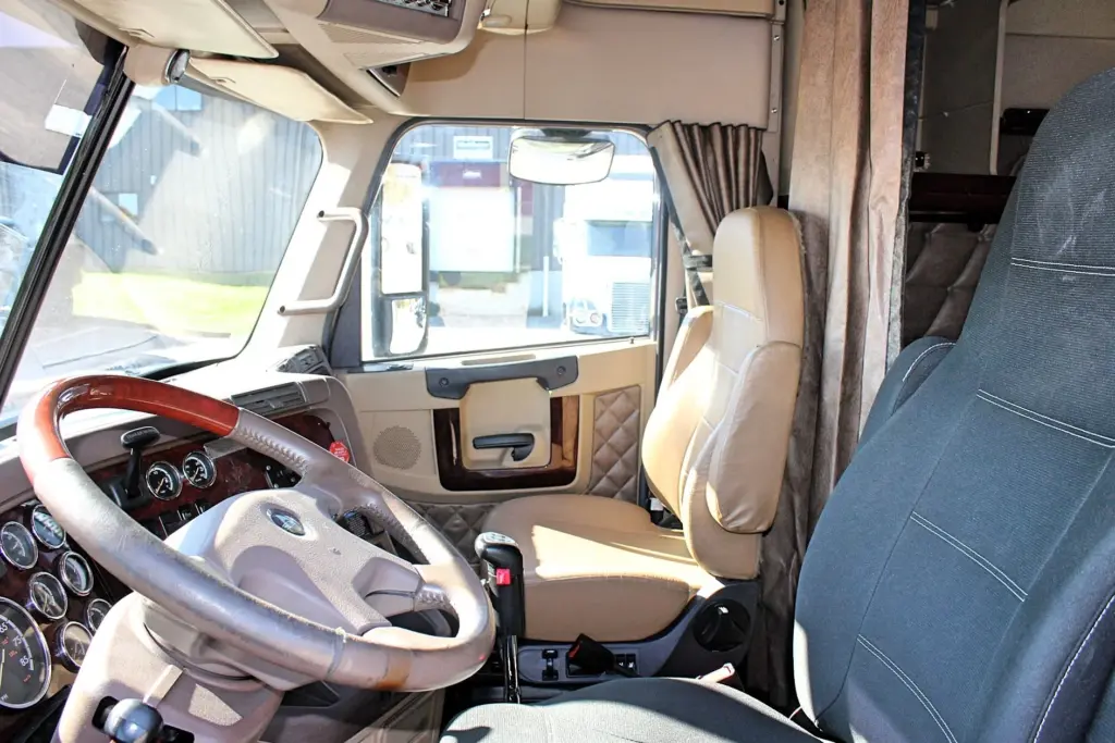 2020 Freightliner Coronado 132 — cab interior with wood-rimmed steering wheel, gauge cluster and tan leather driver seat