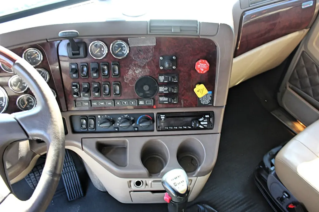 2020 Freightliner Coronado 132 — overhead dash view of wood-trim center console, climate controls, radio and gear shifter