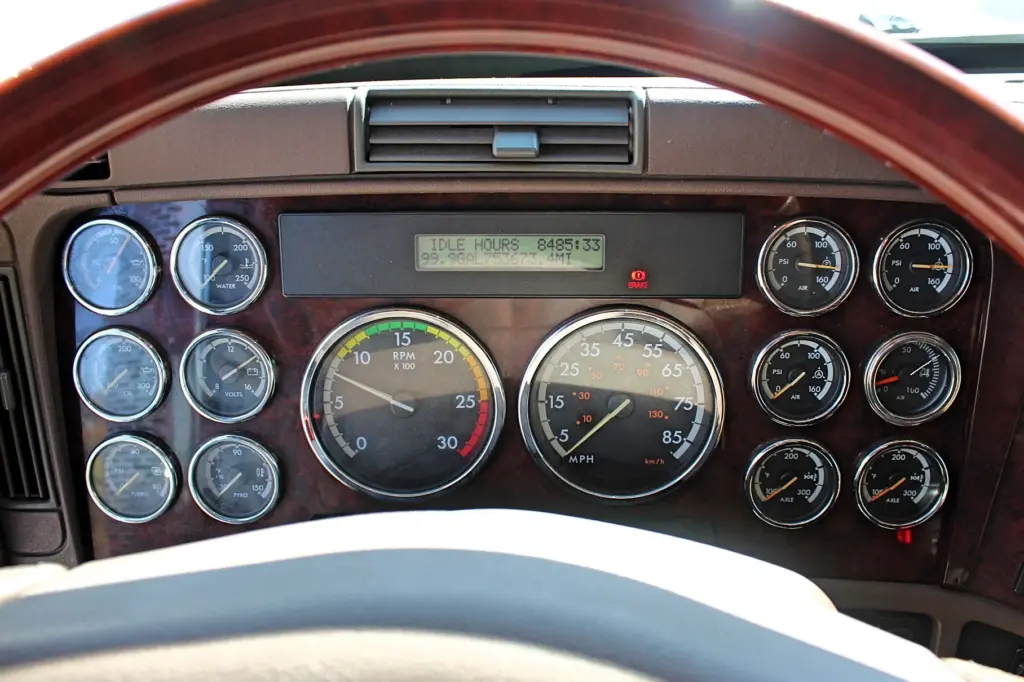 2020 Freightliner Coronado 132 — close view of wood-trim dash with RPM and speed gauges and idle hours display