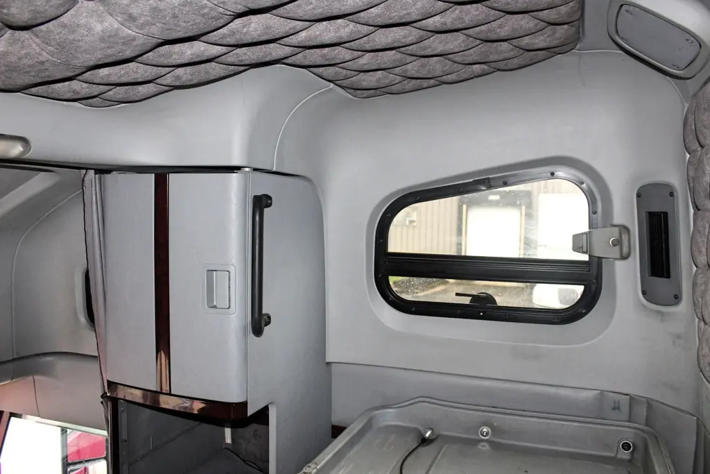 2020 Freightliner Coronado 132 Glider – sleeper interior with side window and tall storage cabinet