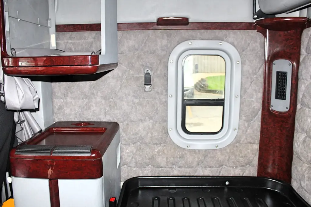 2020 Freightliner Coronado 132 Glider – sleeper interior with wood-grain counter, cabinets and refrigerator