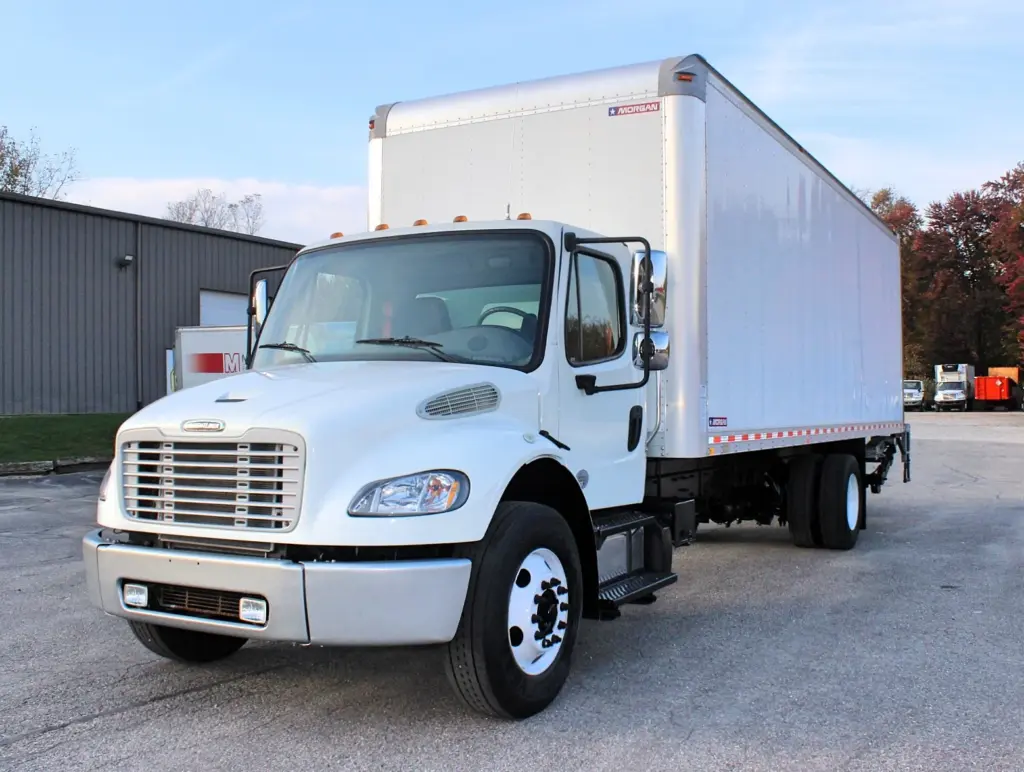 2020 Freightliner M2 106 — angled front view of white box truck with chrome grille, aluminum steer wheel and dry van body
